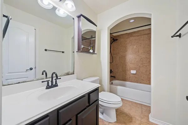 a bathroom with a sink a toilet a mirror and shower