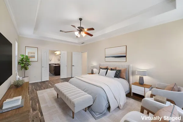 a bedroom with a bed couches and a flat screen tv
