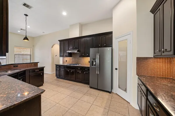 a kitchen with stainless steel appliances granite countertop a refrigerator a sink and a stove