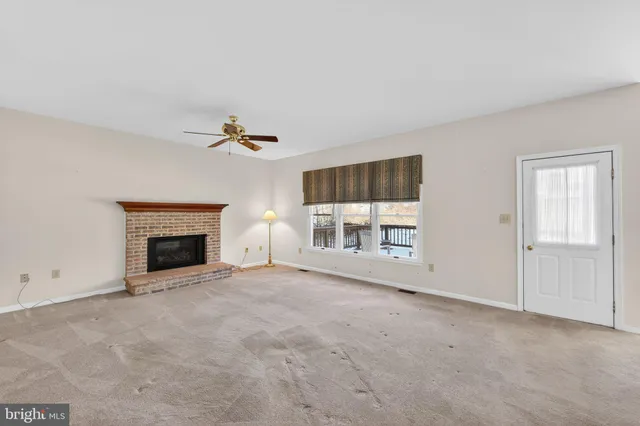 a view of a livingroom with a fireplace and window