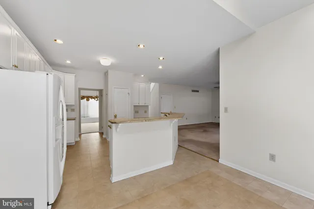 a view of a big room with kitchen and windows