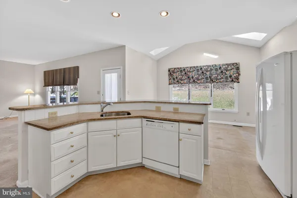 a spacious bathroom with a granite countertop sink a toilet a mirror and shower