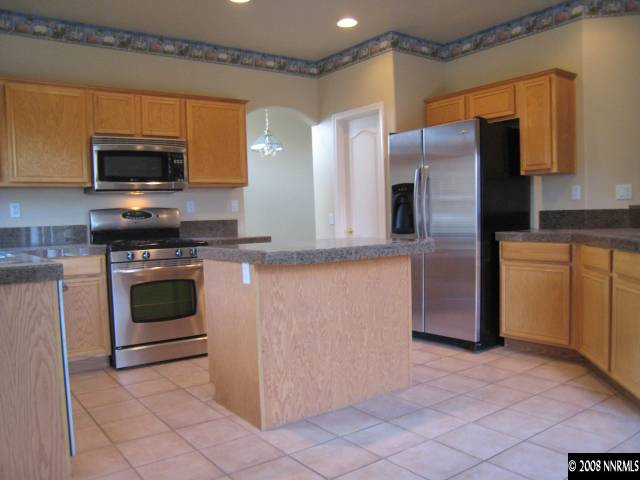 714 Gold Run Court Reno, NV 89521 - Photo 2 of 9 a kitchen with stainless steel appliances granite countertop a stove a refrigerator and a microwave