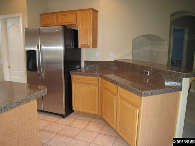 714 Gold Run Court Reno, NV 89521 - Photo 3 of 9 a kitchen with stainless steel appliances granite countertop a sink and a refrigerator