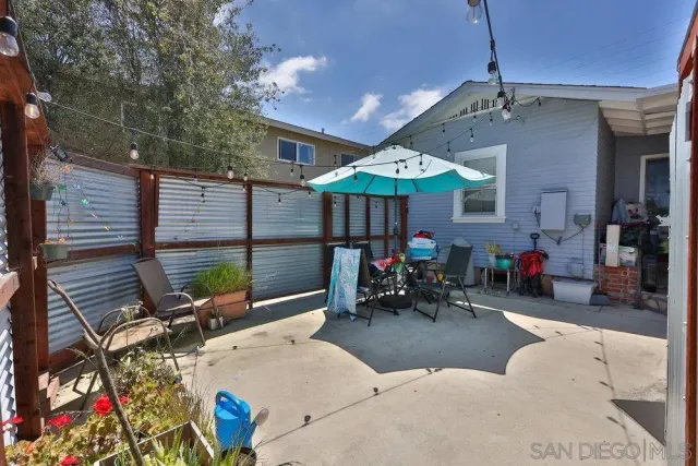 a view of a patio with a table and chairs under an umbrella