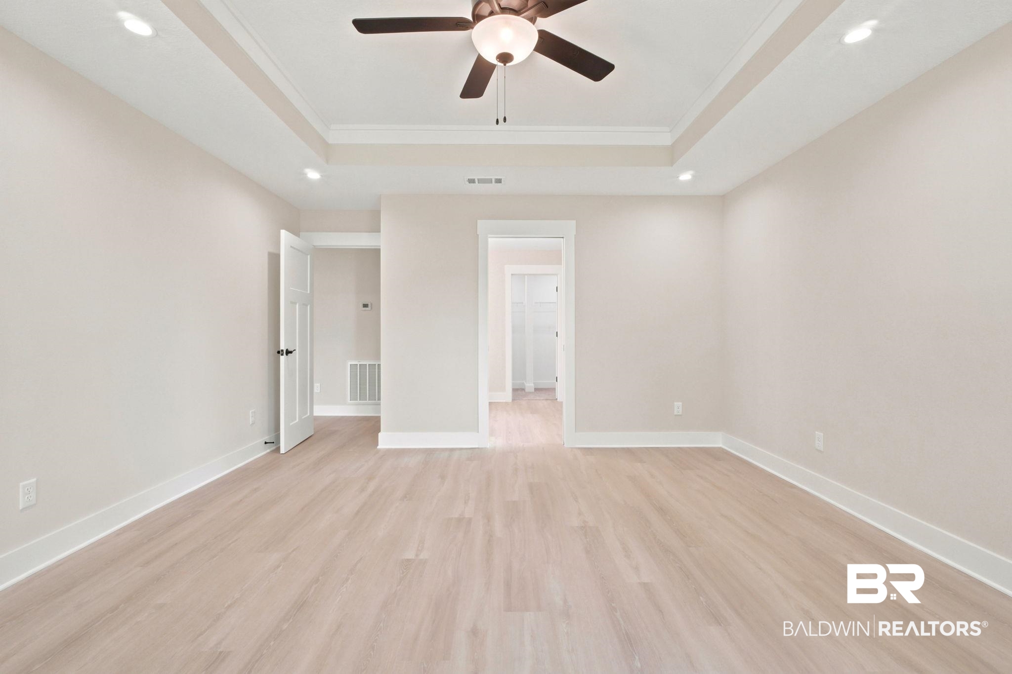 32656 Arbor Ridge Circle Lillian, AL 36549 - Photo 15 of 56 Spacious room featuring light wood-finish flooring, a tray ceiling with recessed lighting, a ceiling fan, and white baseboards and trim