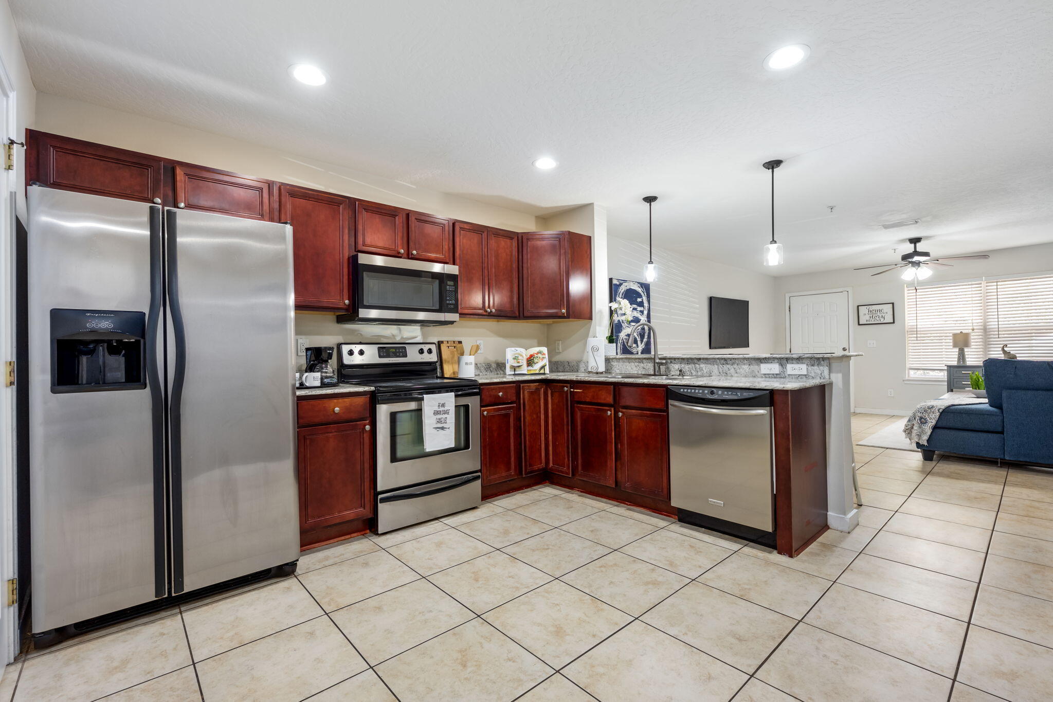 108 Hawkins Road, Unit E Fort Walton Beach, FL 32547 - Photo 11 of 41 a kitchen with stainless steel appliances kitchen island granite countertop a refrigerator and a sink