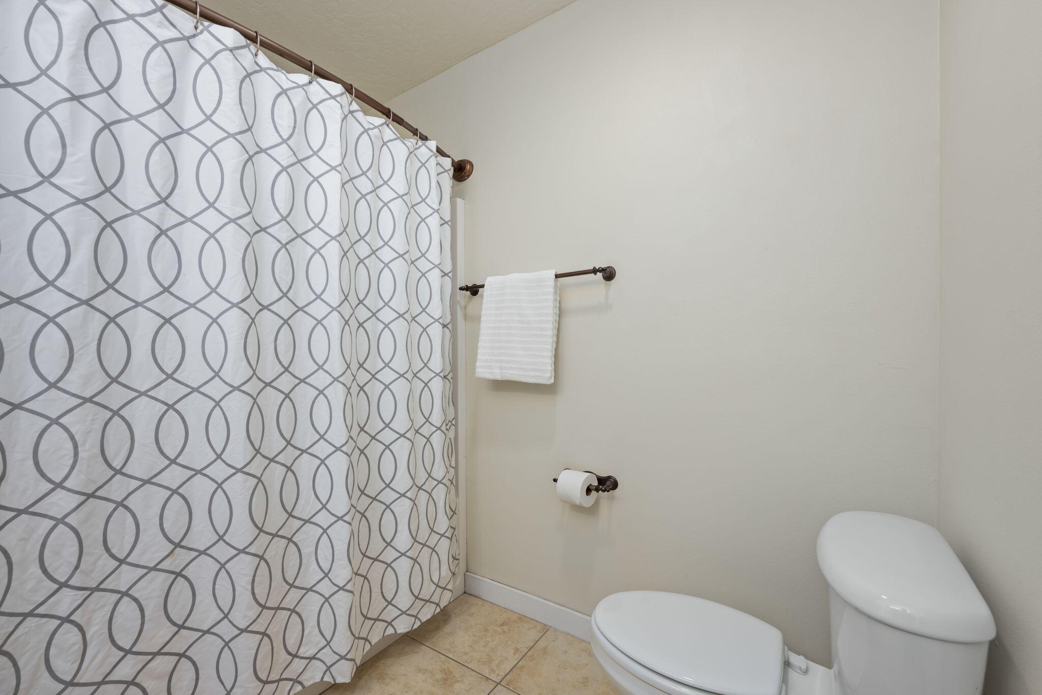 108 Hawkins Road, Unit E Fort Walton Beach, FL 32547 - Photo 29 of 41 a white toilet sitting next to a shower curtain