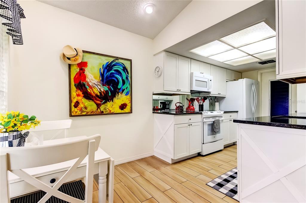 4756 Sheffield Drive New Port Richey, FL 34655 - Photo 12 of 30 a kitchen with stainless steel appliances kitchen island granite countertop a refrigerator and a stove top oven