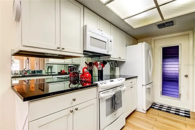 a kitchen with stainless steel appliances granite countertop a refrigerator and a stove top oven