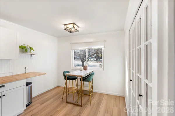 a dining room with wooden floor and a hallway