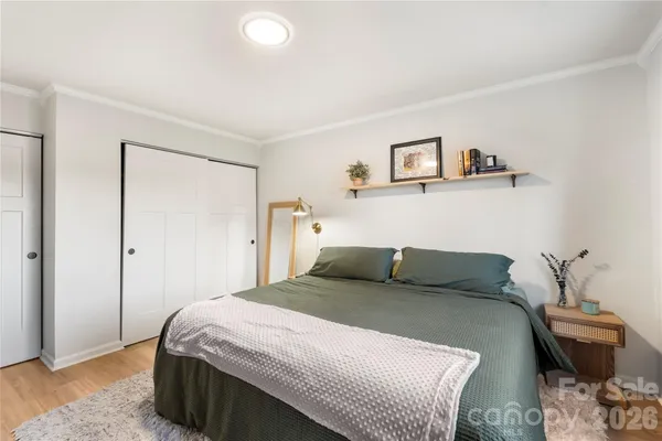 a bedroom with a bed and wooden floor