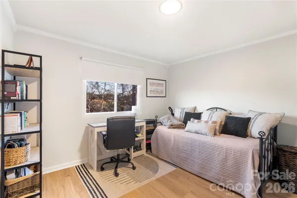 a bedroom with a bed a book shelf and a window