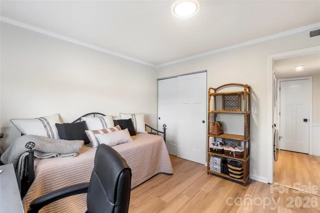 a bedroom with a bed and a wooden floor