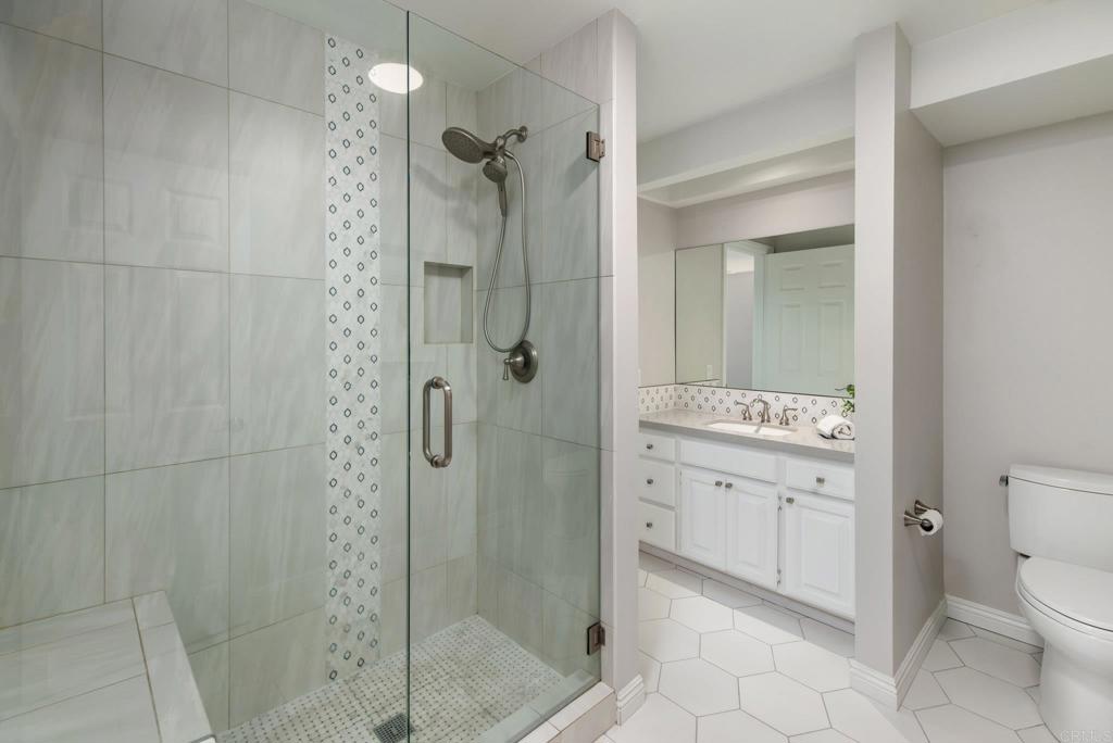 2515 Luciernaga Street Carlsbad, CA 92009 - Photo 36 of 58 a bathroom with a granite countertop shower a mirror and a sink