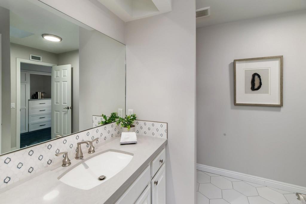 2515 Luciernaga Street Carlsbad, CA 92009 - Photo 37 of 58 a bathroom with a granite countertop sink and a mirror