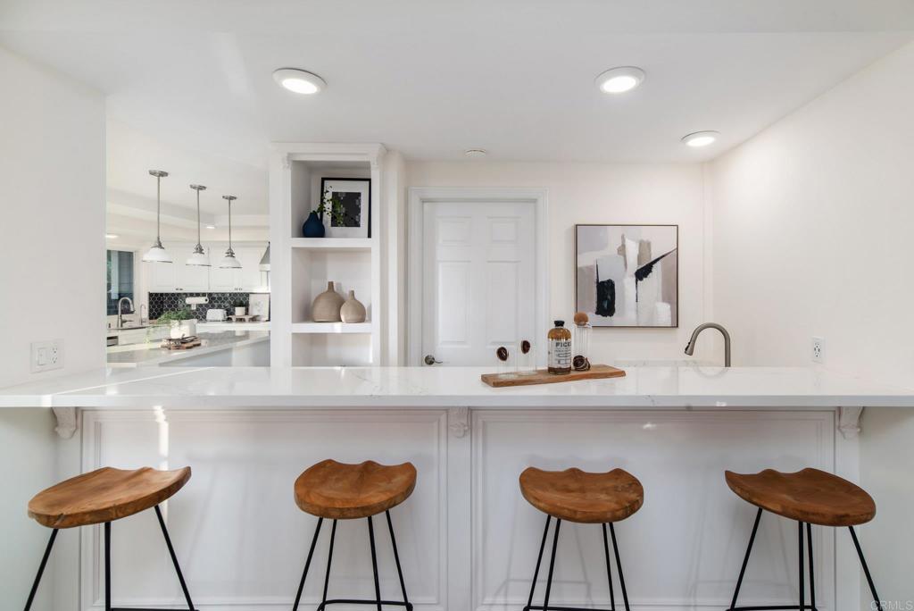 2515 Luciernaga Street Carlsbad, CA 92009 - Photo 8 of 58 a kitchen with stainless steel appliances granite countertop a kitchen island and chairs in it