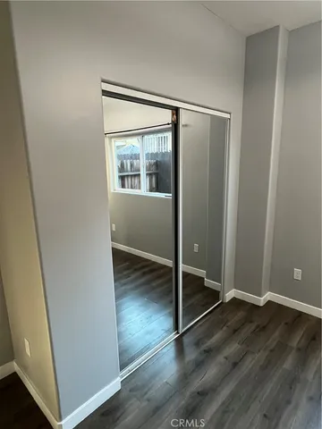 an empty room with wooden floor and entrance