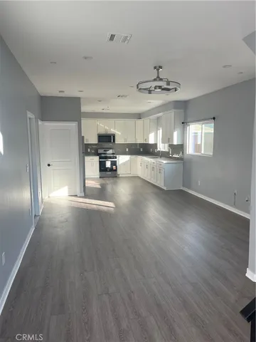 a view of a kitchen with furniture wooden floor and window