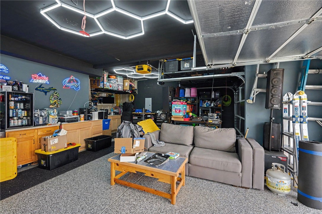 3011 Falls Road Clayton, OH 45315 - Photo 54 of 66 A well-lit garage offers ample space for storage and relaxation, featuring a versatile epoxy floor.