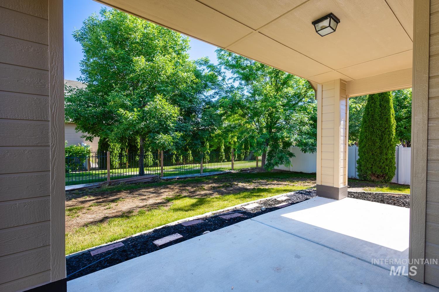 1186 East Observation Street Meridian, ID 83642 - Photo 30 of 33 Covered concrete patio overlooking a fenced backyard with mature trees