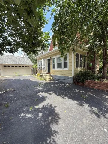 a view of a house with backyard and a tree