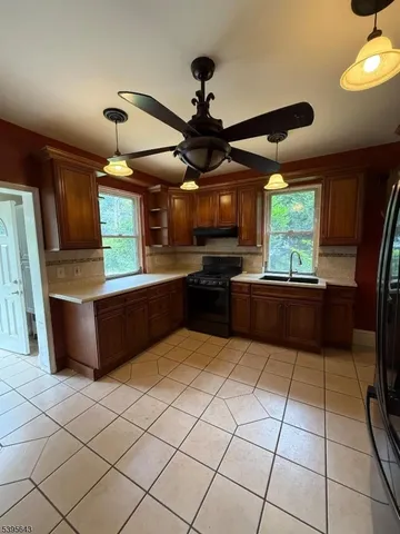 a kitchen with stainless steel appliances granite countertop a sink counter space cabinets and a window