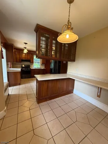 a large kitchen with stainless steel appliances a stove a sink a counter space and cabinets