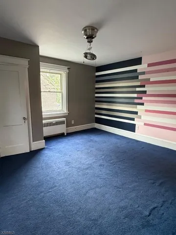 a view of empty room with ceiling fan and window