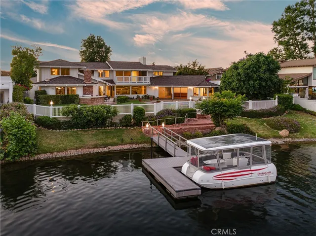 an aerial view of a house with outdoor space and lake view in back