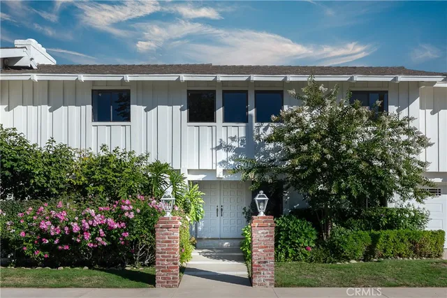 a front view of a house with a garden