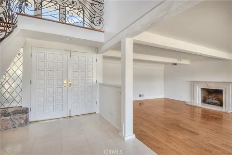 an empty room with windows and fireplace