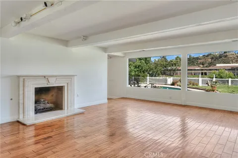 wooden floor fireplace and windows in an empty room