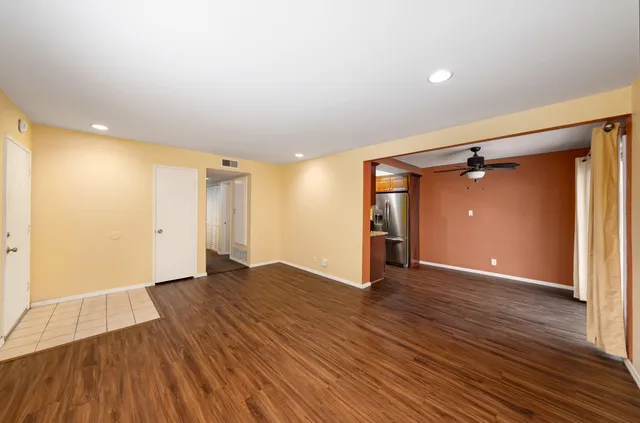 a view of an empty room with wooden floor