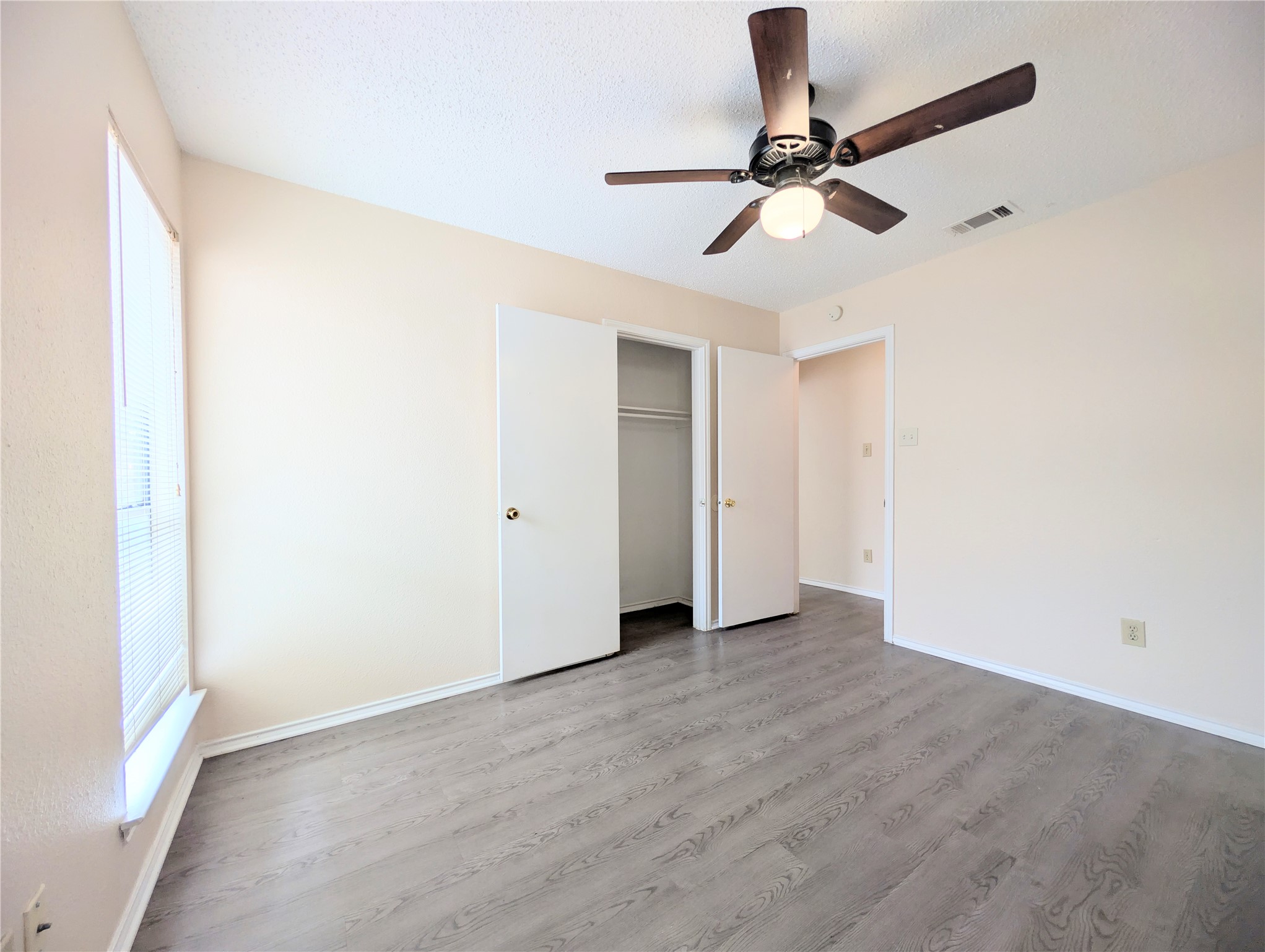 2018 Redwing Way Round Rock, TX 78664 - Photo 14 of 27 Guest Bedroom #1 Interior room featuring wood-finish flooring, a ceiling fan with integrated lighting, and a window with horizontal blinds