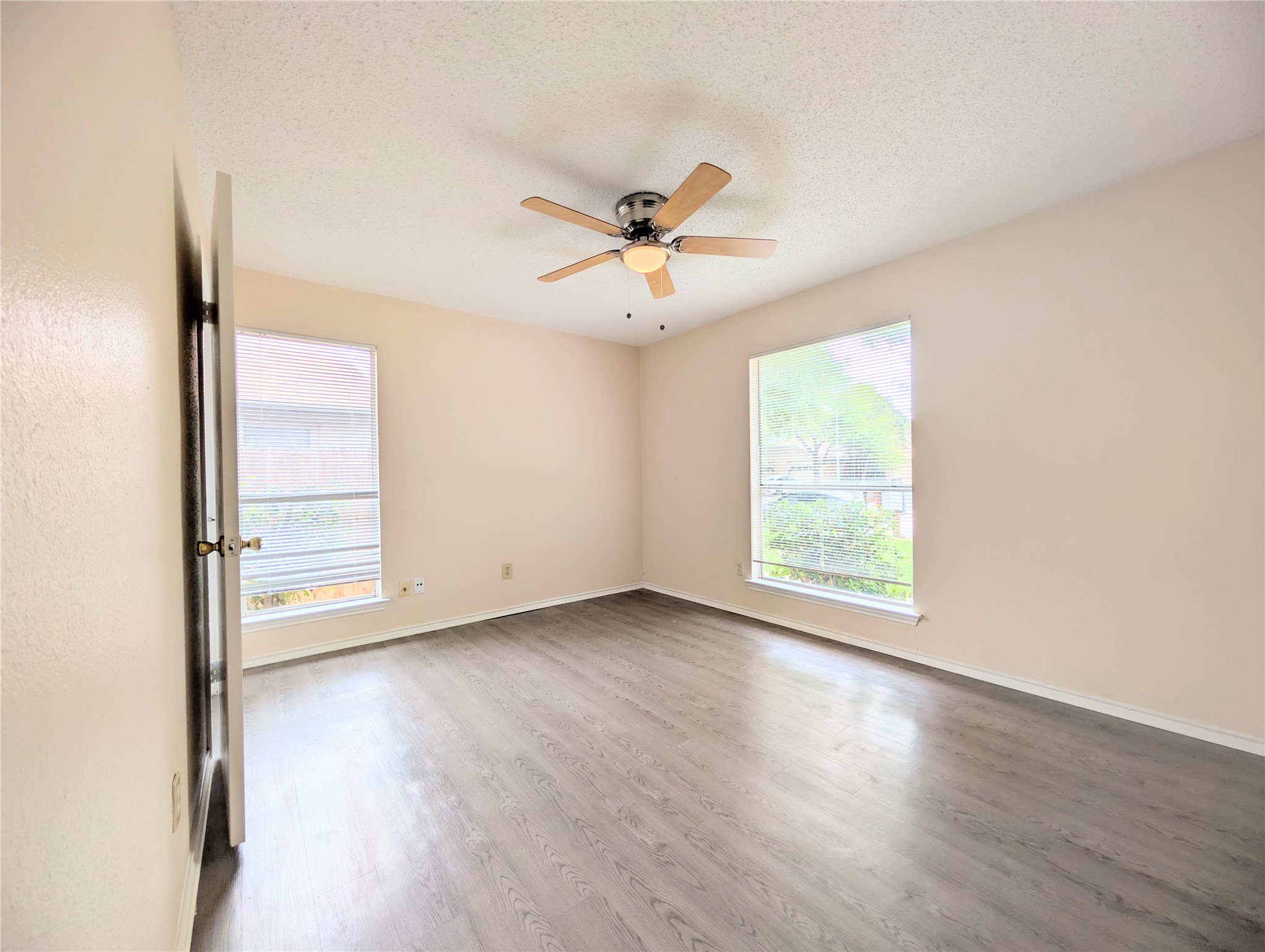 2018 Redwing Way Round Rock, TX 78664 - Photo 16 of 27 Guest Bedroom #2 Spacious room featuring wood-finish flooring, light-toned walls, and a ceiling fan with integrated lighting