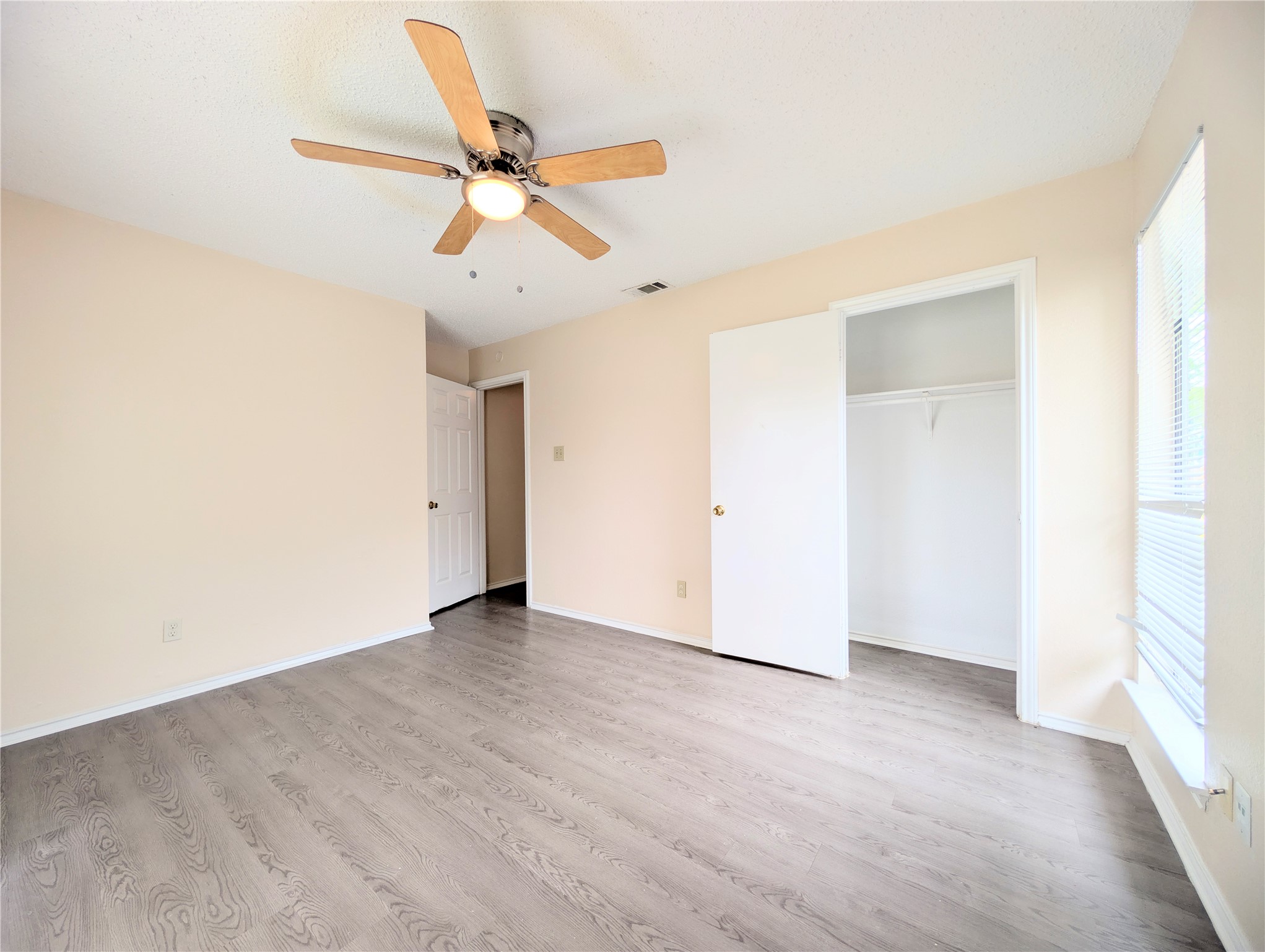 2018 Redwing Way Round Rock, TX 78664 - Photo 17 of 27 Guest Bedroom #2 Room with wood-finish flooring, light-colored walls, and a ceiling fan with integrated lighting