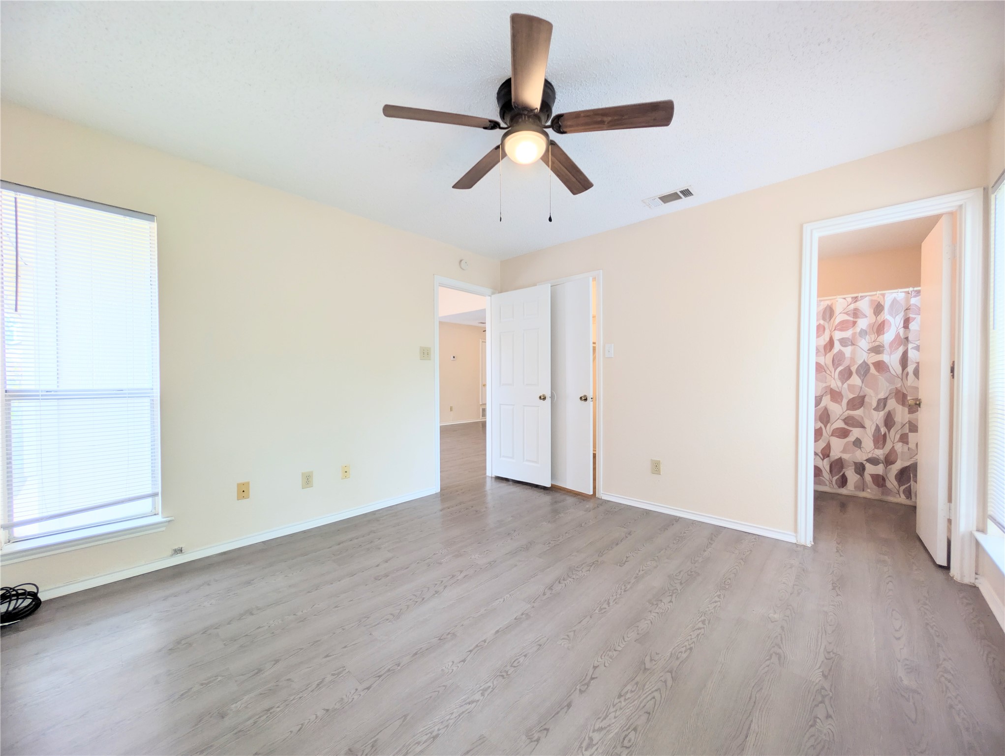 2018 Redwing Way Round Rock, TX 78664 - Photo 20 of 27 Primary bedroom featuring light wood-finish flooring, a ceiling fan with integrated lighting, and neutral wall tones