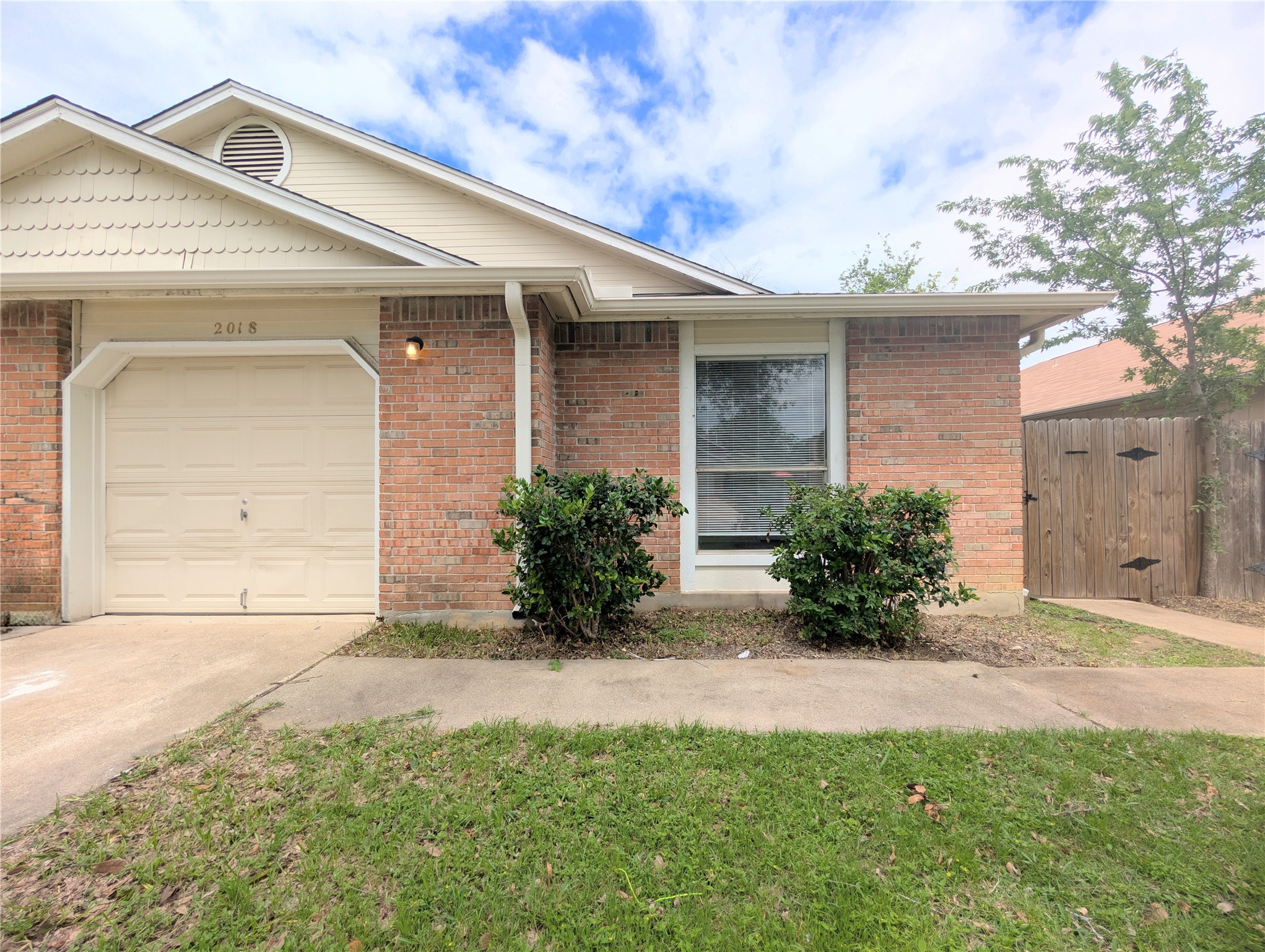 2018 Redwing Way Round Rock, TX 78664 - Photo 2 of 27 Brick exterior featuring a single-car garage and a paved driveway