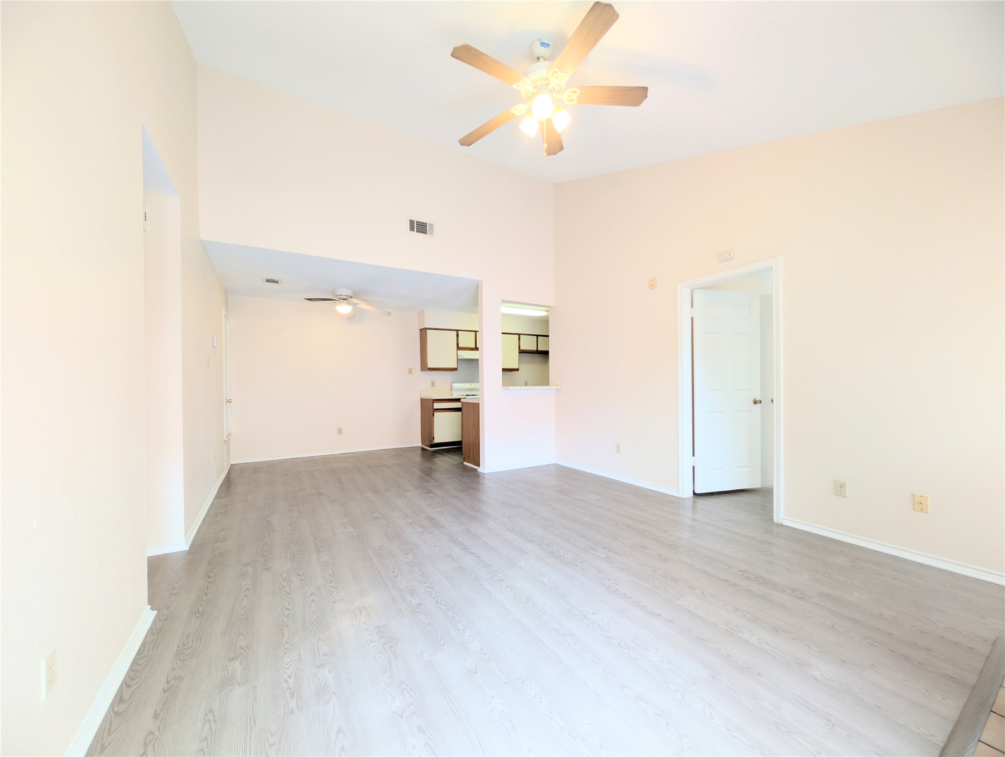 2018 Redwing Way Round Rock, TX 78664 - Photo 7 of 27 Spacious room featuring vaulted ceilings, wood-finish flooring, and a ceiling fan with integrated lighting