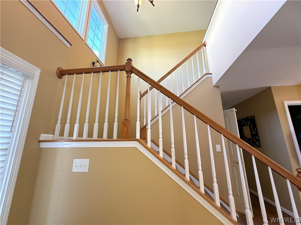 73 Chestnut Lancaster, NY 14086 - Photo 4 of 41 An elegant wooden staircase rises past classic moldings and high clerestory windows.