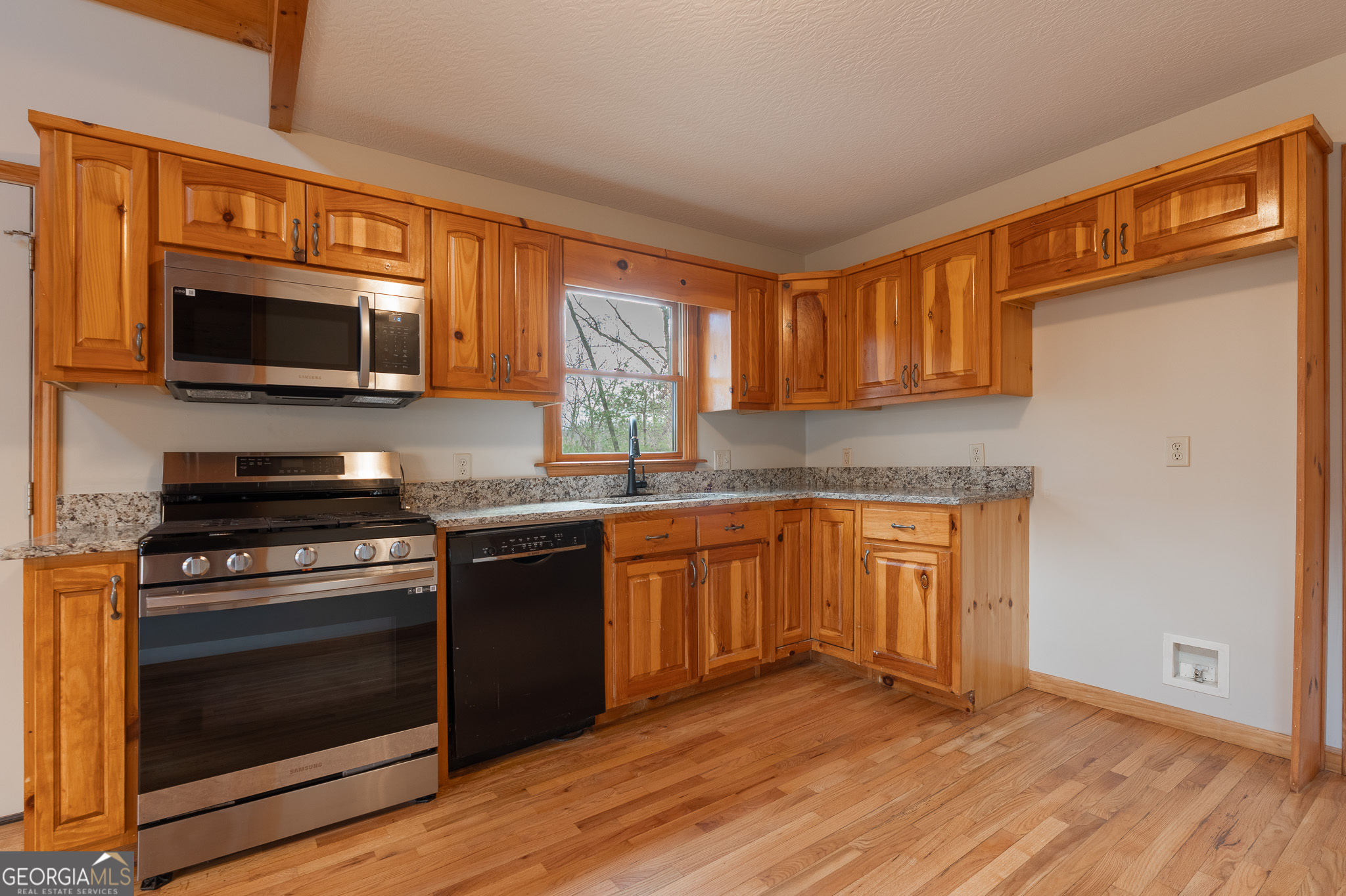 148 Gradient Court Ellijay, GA 30540 - Photo 20 of 28 a kitchen with granite countertop wooden cabinets stainless steel appliances and a window