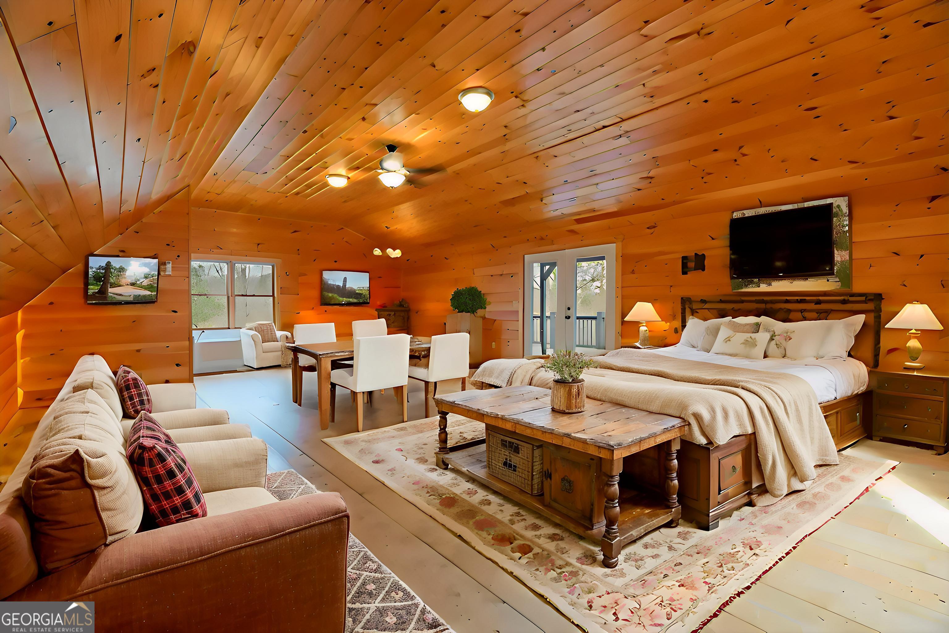 148 Gradient Court Ellijay, GA 30540 - Photo 27 of 28 a spacious bedroom with a bed a couch and a chandelier