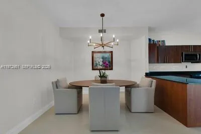 a dining hall with granite countertop a sink dishwasher a dining table and chairs with wooden floor