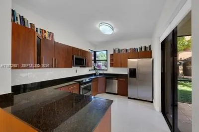 a kitchen with stainless steel appliances granite countertop a sink a refrigerator and a stove