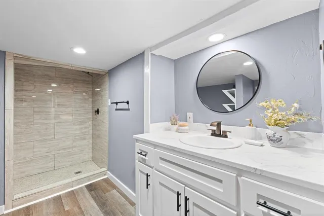 a bathroom with a sink mirror and shower