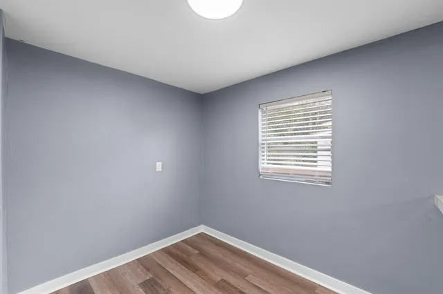 a view of a room with wooden floor and a window