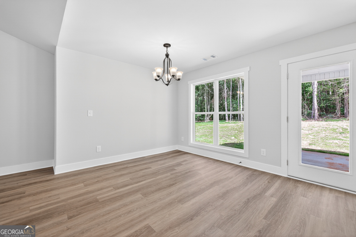 206 Airport Road, Unit 11 Canon, GA 30520 - Photo 16 of 34 a view of an empty room with wooden floor and a window