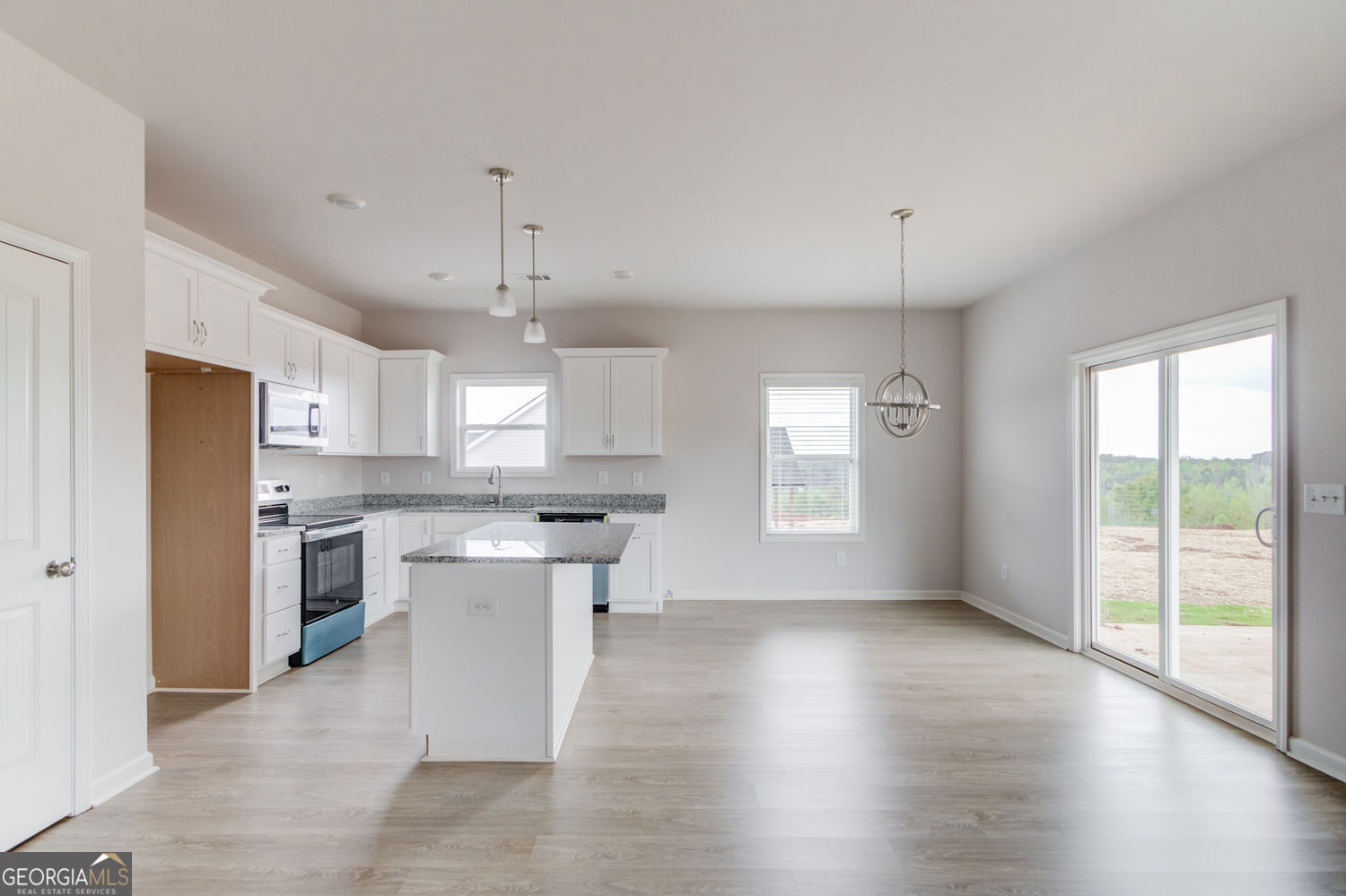 255 Cool Springs Road, Unit ROAD 7 Clarkesville, GA 30523 - Photo 12 of 42 a kitchen with stainless steel appliances granite countertop a stove a sink dishwasher a refrigerator white cabinets and wooden floor next to a window