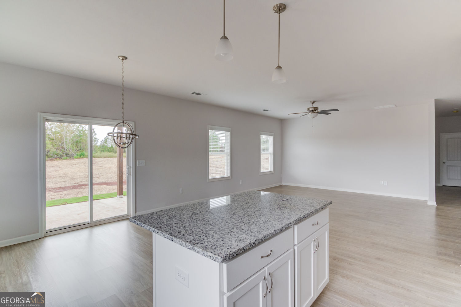 255 Cool Springs Road, Unit ROAD 7 Clarkesville, GA 30523 - Photo 16 of 42 a kitchen with kitchen island a sink wooden floor and a large window